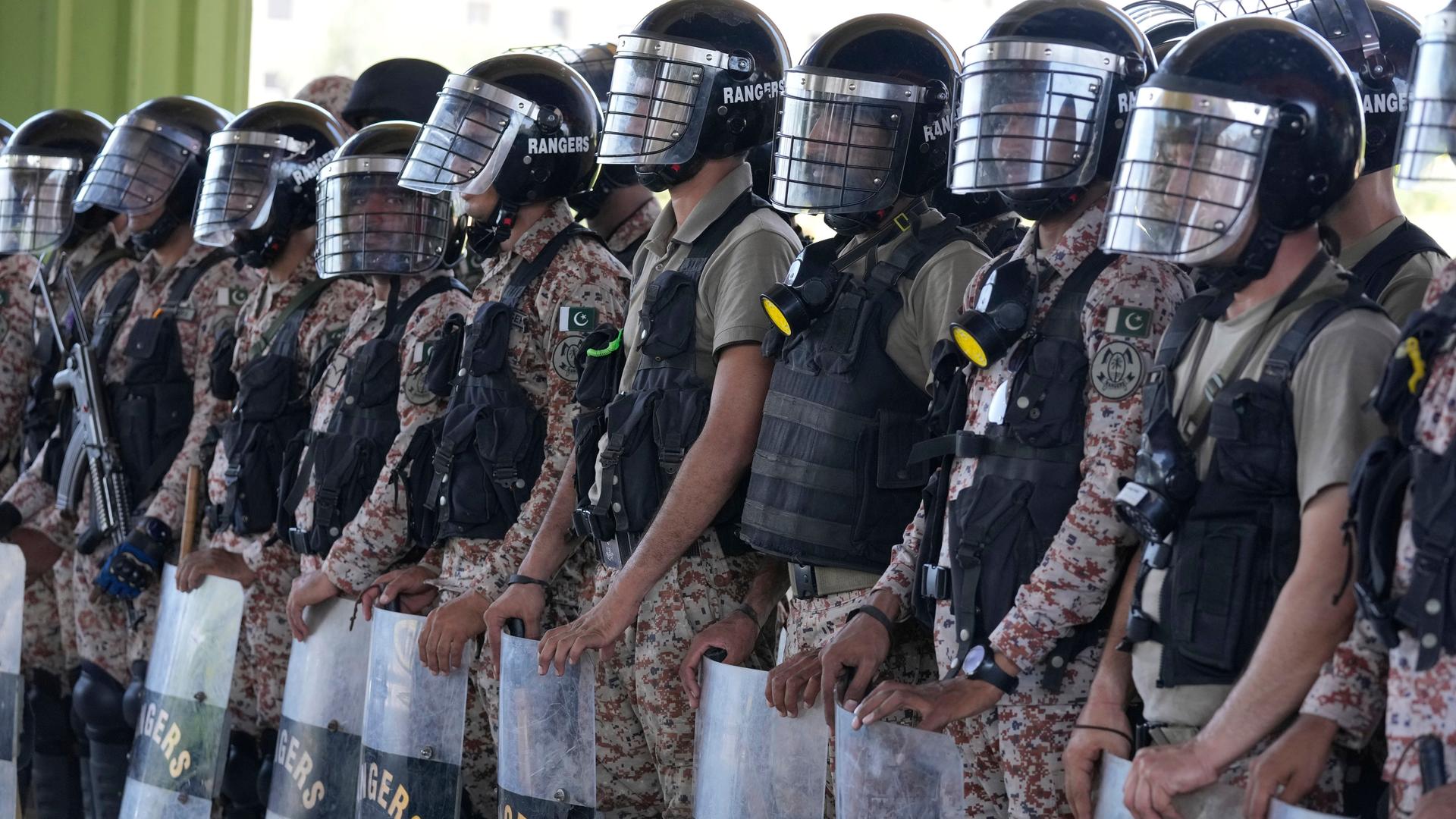 Soldaten stehen in Karachi, Pakistan, in einer Reihe. Sie tragen Schutzhelme und Schutzschilder. Soldaten stehen in Karachi, Pakistan, in einer Reihe. Sie tragen Schutzhelme und Schutzschilder.