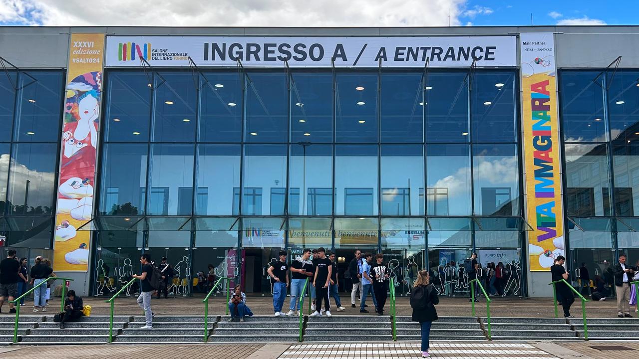 Menschen stehen an einem Eingang zur Buchmesse Salone Internazionale del Libro in Turin.
