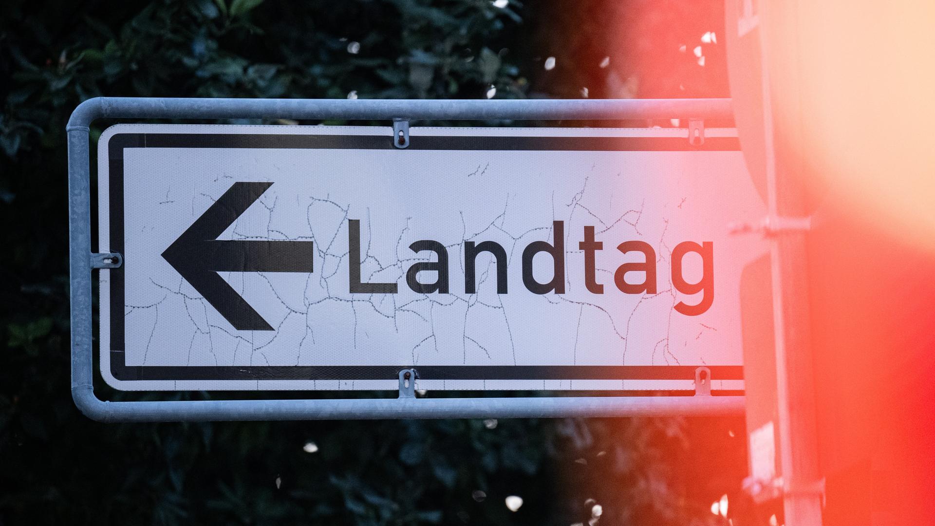 Auf einem Straßenschild steht der Schriftzug "Landtag" mit einem Pfeil.