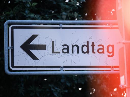 Auf einem Straßenschild steht der Schriftzug "Landtag" mit einem Pfeil.