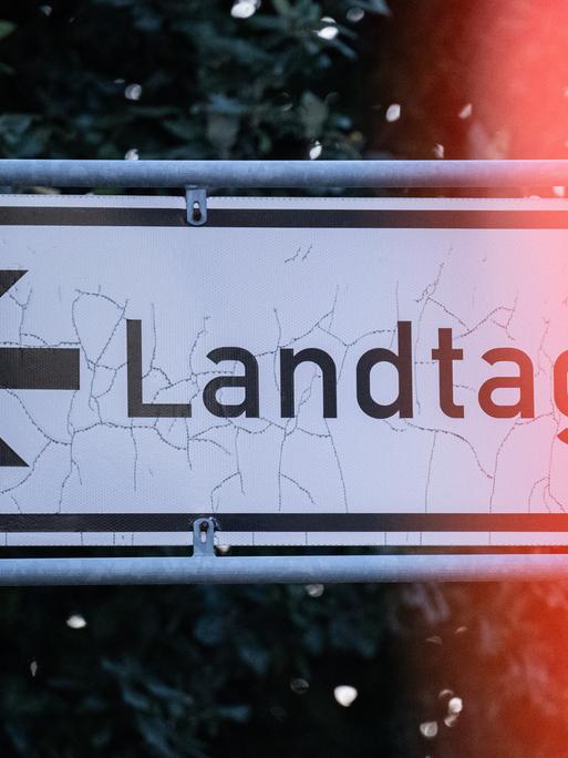 Auf einem Straßenschild steht der Schriftzug "Landtag" mit einem Pfeil.