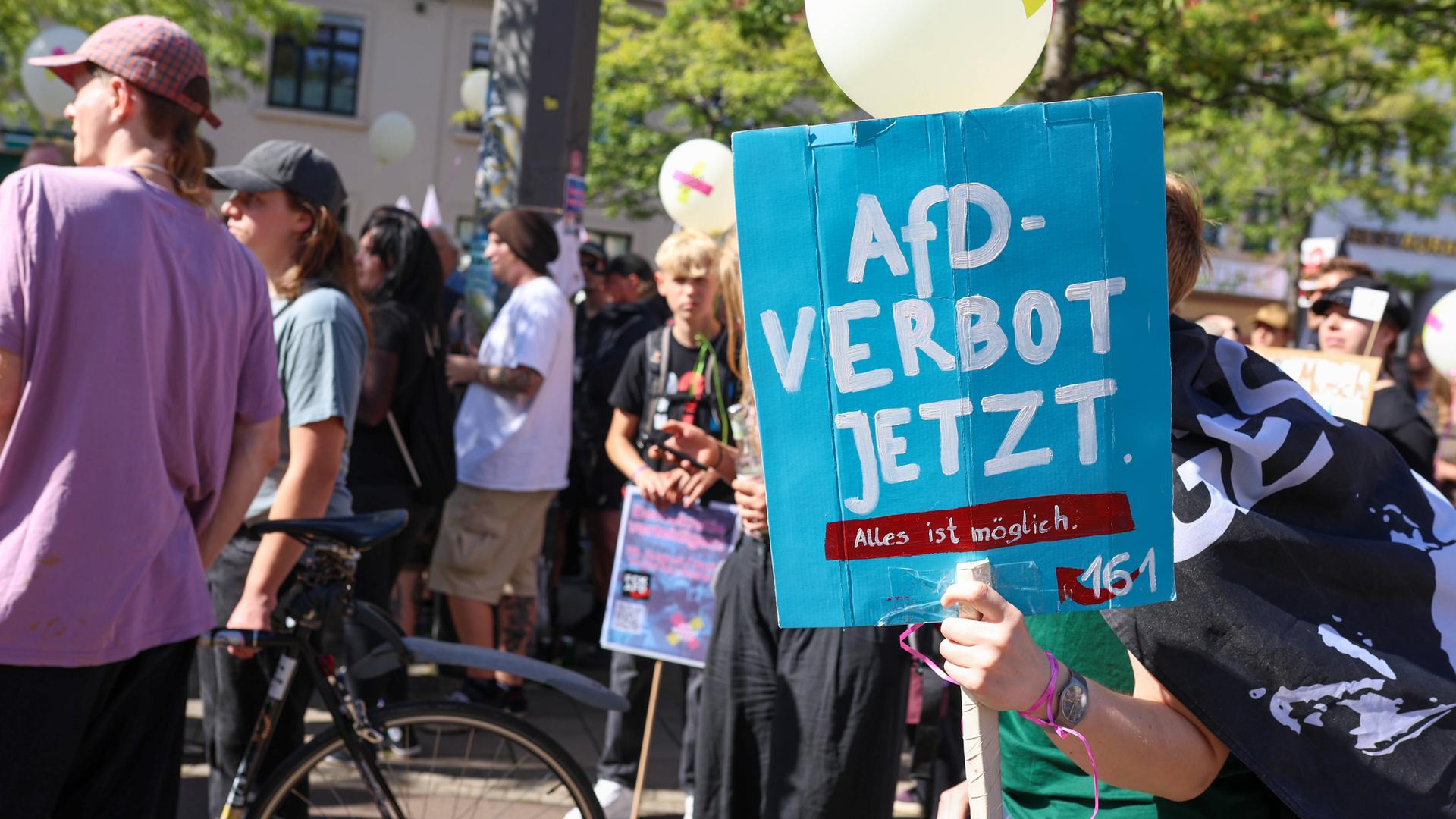 Ein Demonstrant hält ein Plakat mit der Aufschrift "AfD-Verbot jetzt" hoch