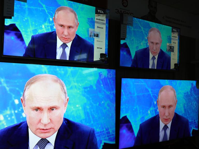Das Gesicht Wladimir Putins vierfach auf einem Bildschirm.