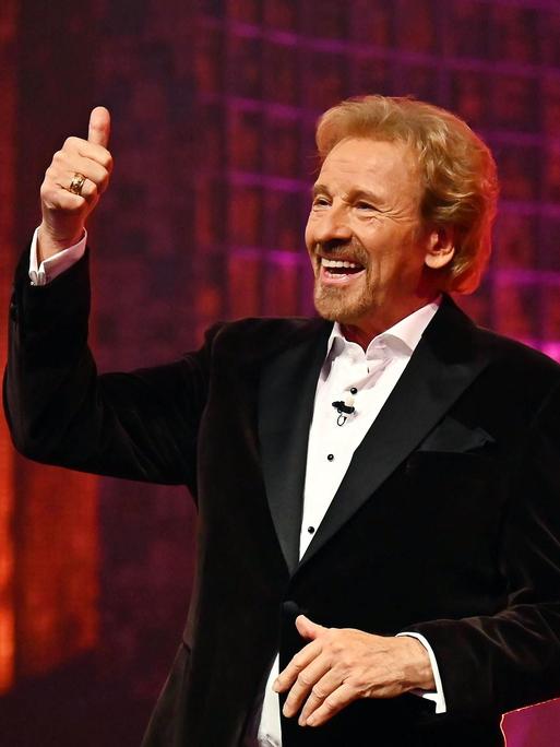 Thomas Gottschalk hält den Daumen hoch und lacht. Neben ihm steht Günther Jauch und applaudiert. 