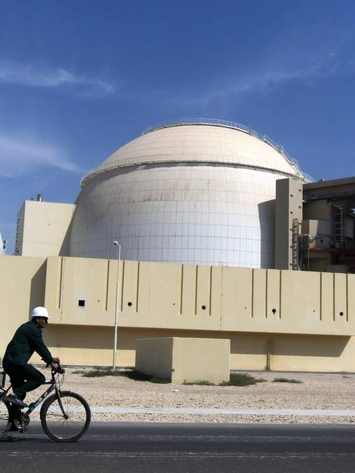 Arbeiter auf einem Fahrrad vor dem Atommeiler von Bushehr im Iran