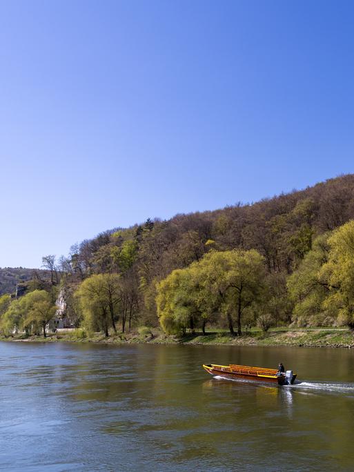 Ein Mann fährt mit einem Boot auf der Donau.
