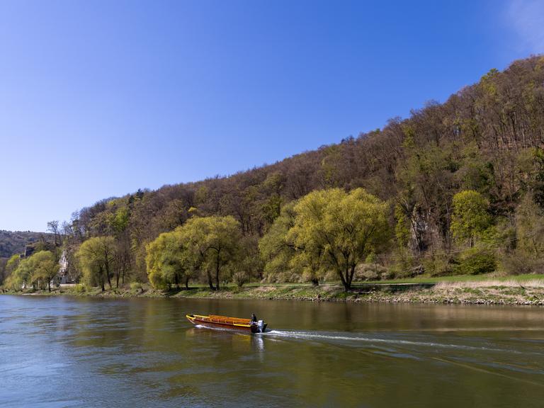 Ein Mann fährt mit einem Boot auf der Donau.