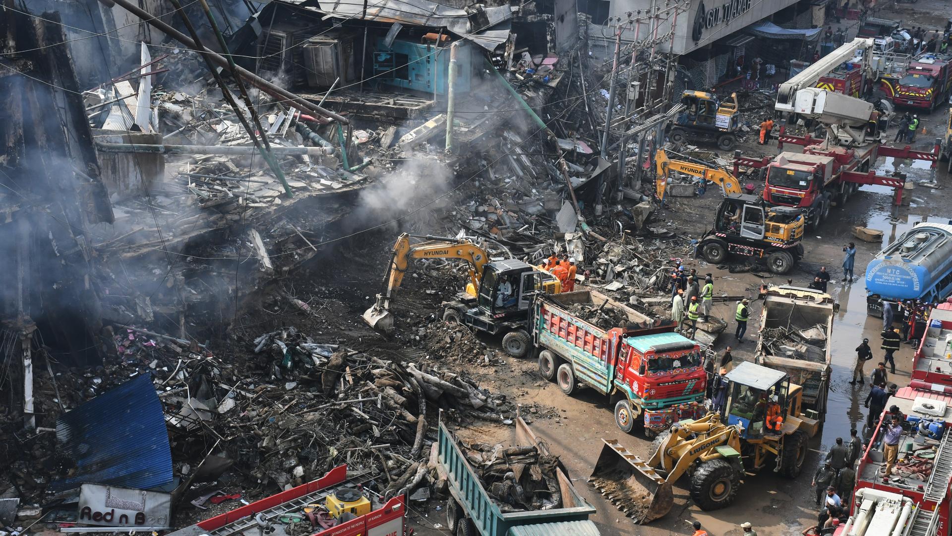 Karachi: Rettungskräfte und Feuerwehrleute durchsuchen mit schwerem Gerät die Trümmer eines abgebrannten Gebäudes in einem mehrstöckigen Einkaufszentrum nach einem Großbrand. 