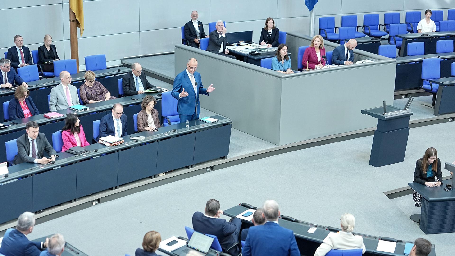 Bundeskanzler Friedrich Merz (CDU, hinten, M,l) spricht im Plenum des Bundestags bei der Regierungsbefragung.