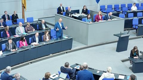 Bundeskanzler Friedrich Merz (CDU, hinten, M,l) spricht im Plenum des Bundestags bei der Regierungsbefragung.