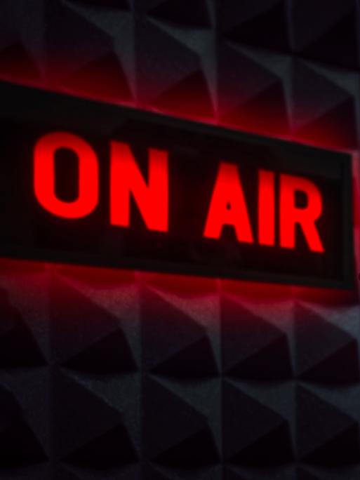 Radiostudio mit einem Mikrofon und einem Schild, das "On Air" anzeigt