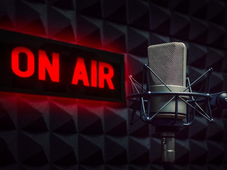 Radiostudio mit einem Mikrofon und einem Schild, das "On Air" anzeigt