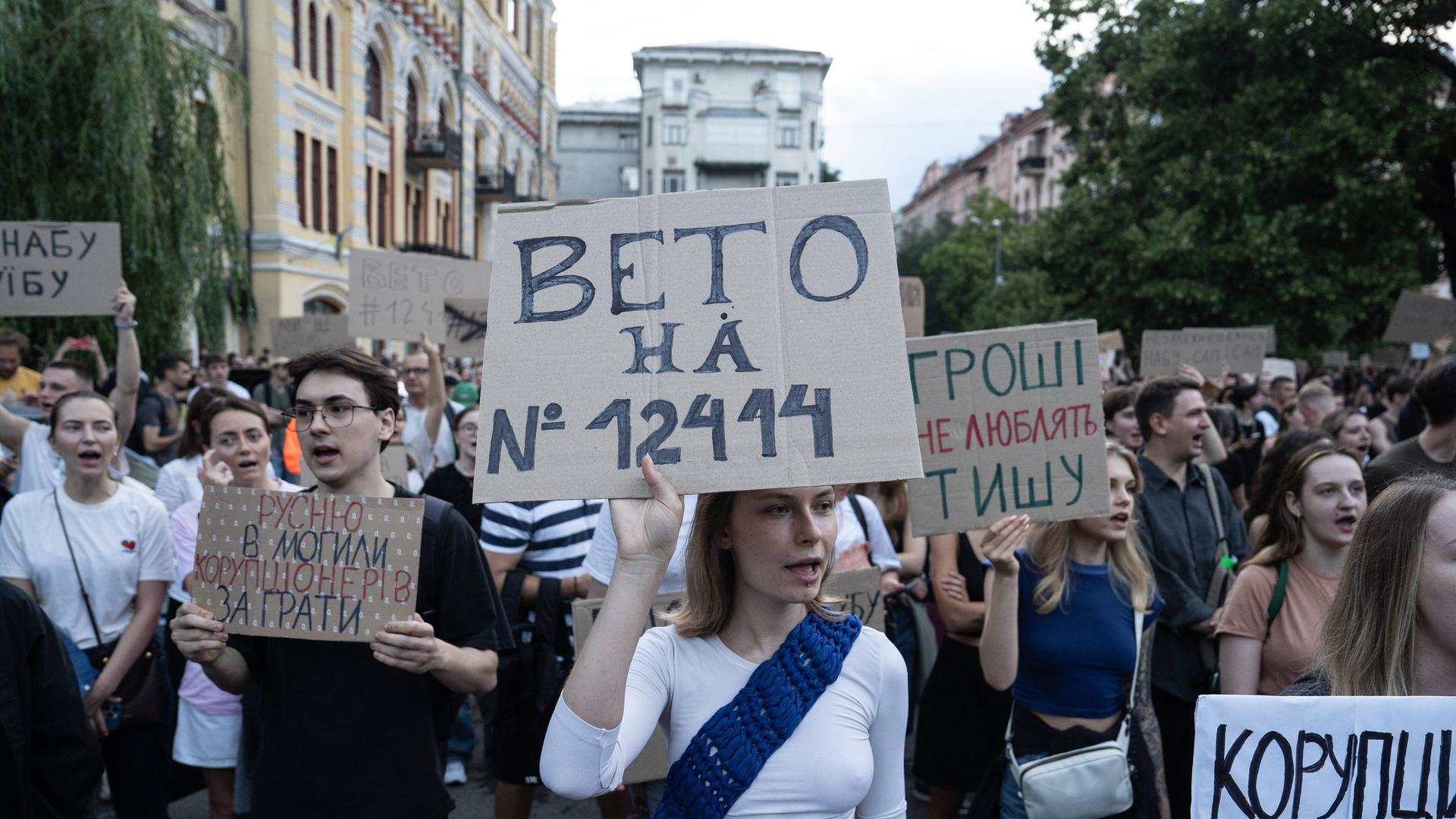 Demonstrierende mit Schildern protestieren gegen ein Gesetz, das dem Nationalen Antikorruptionsbüro (NABU) und der Speziellen Antikorruptionsstaatsanwaltschaft (SAPO) ihre Unabhängigkeit entzieht.