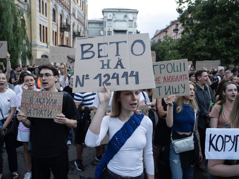 Demonstrierende mit Schildern protestieren gegen ein Gesetz, das dem Nationalen Antikorruptionsbüro (NABU) und der Speziellen Antikorruptionsstaatsanwaltschaft (SAPO) ihre Unabhängigkeit entzieht.