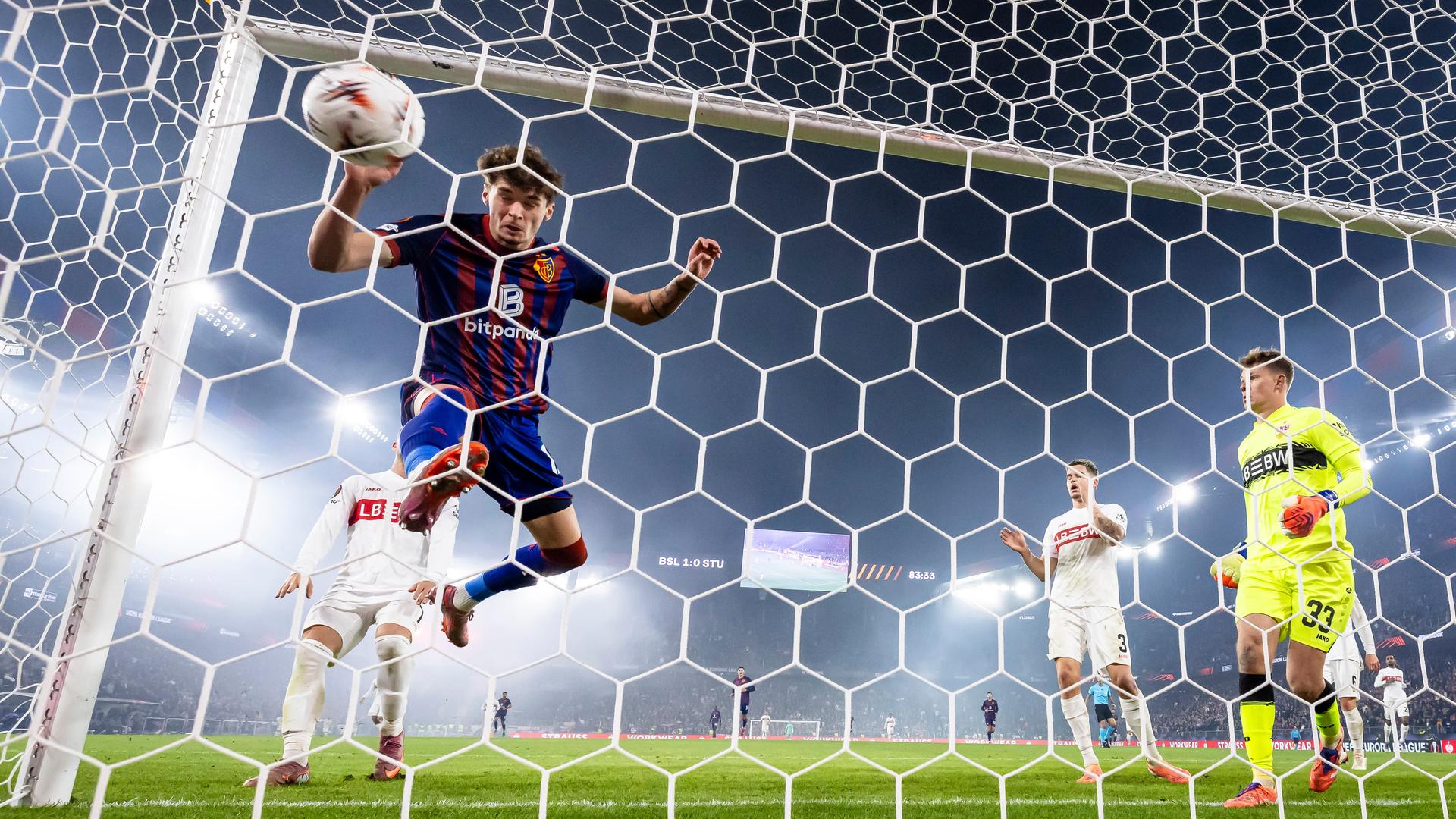 02.10.2025, Schweiz, Basel: Moritz Broschinski vom FC Basel (l) trifft zum 2:0 gegen VfB Stuttgarts Torhüter Alexander Nuebel (r) neben Ramon Hendriks (2.v.r).