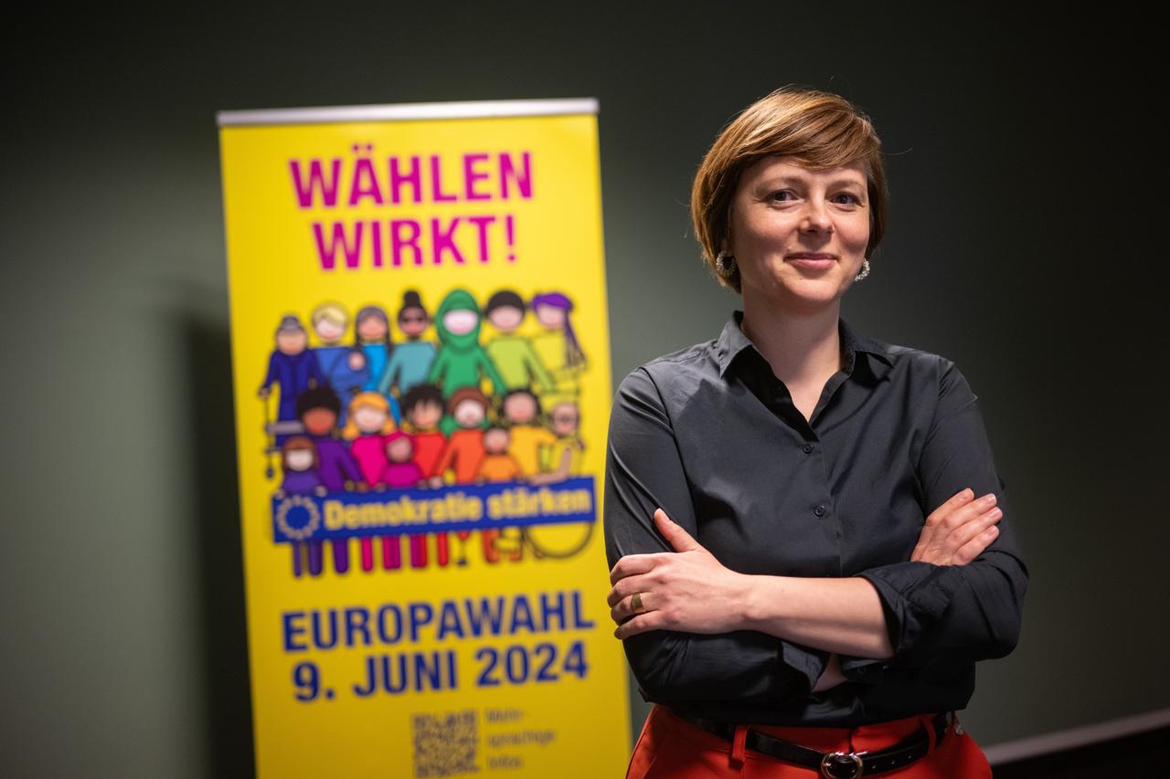 Katarina Niewiedzial steht vor einem Plakat zur Europa-Wahl.