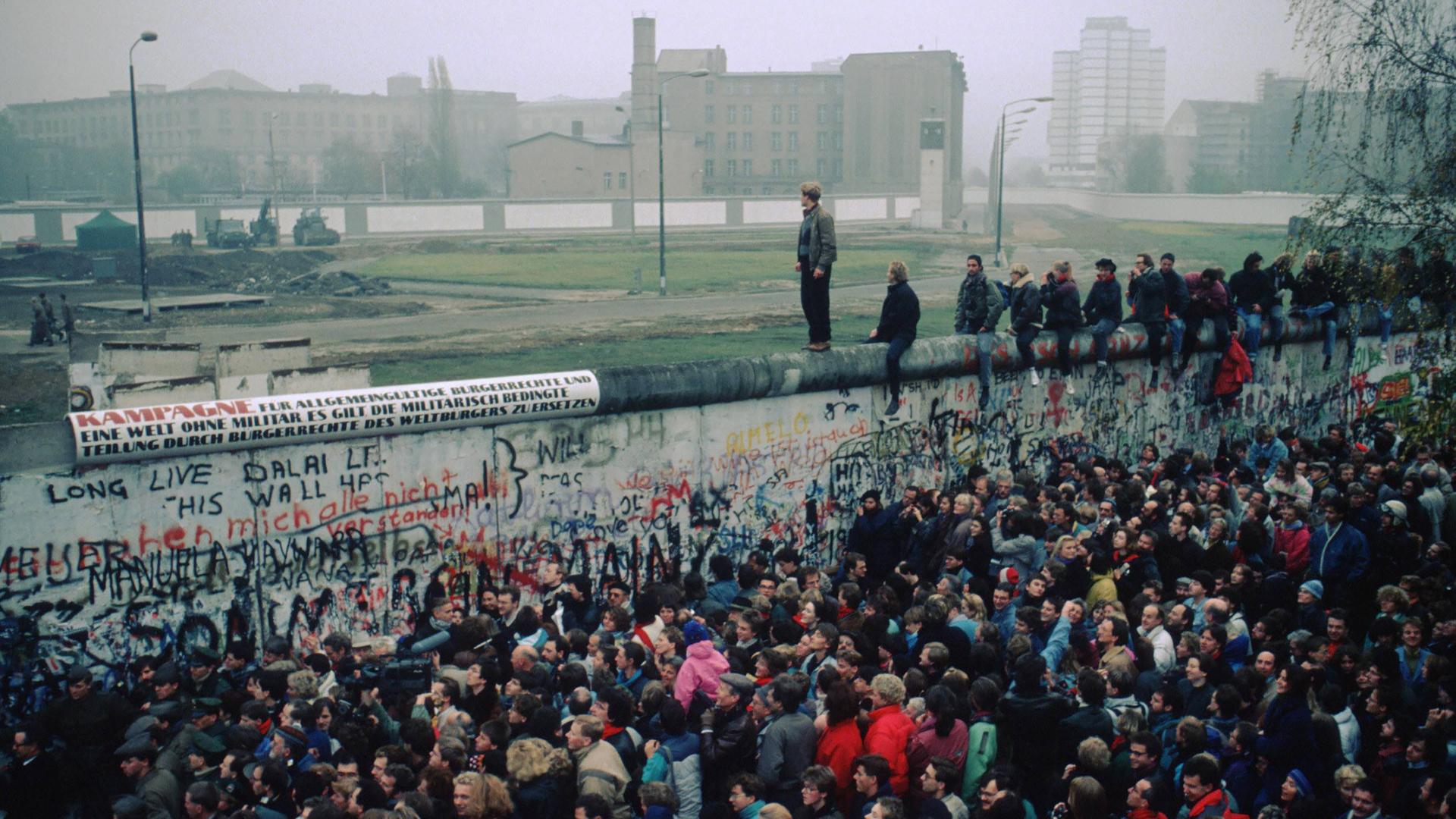 Menschenmasse vor und auf der Berliner Mauer. Grenzöffnung am 9. November 1989.