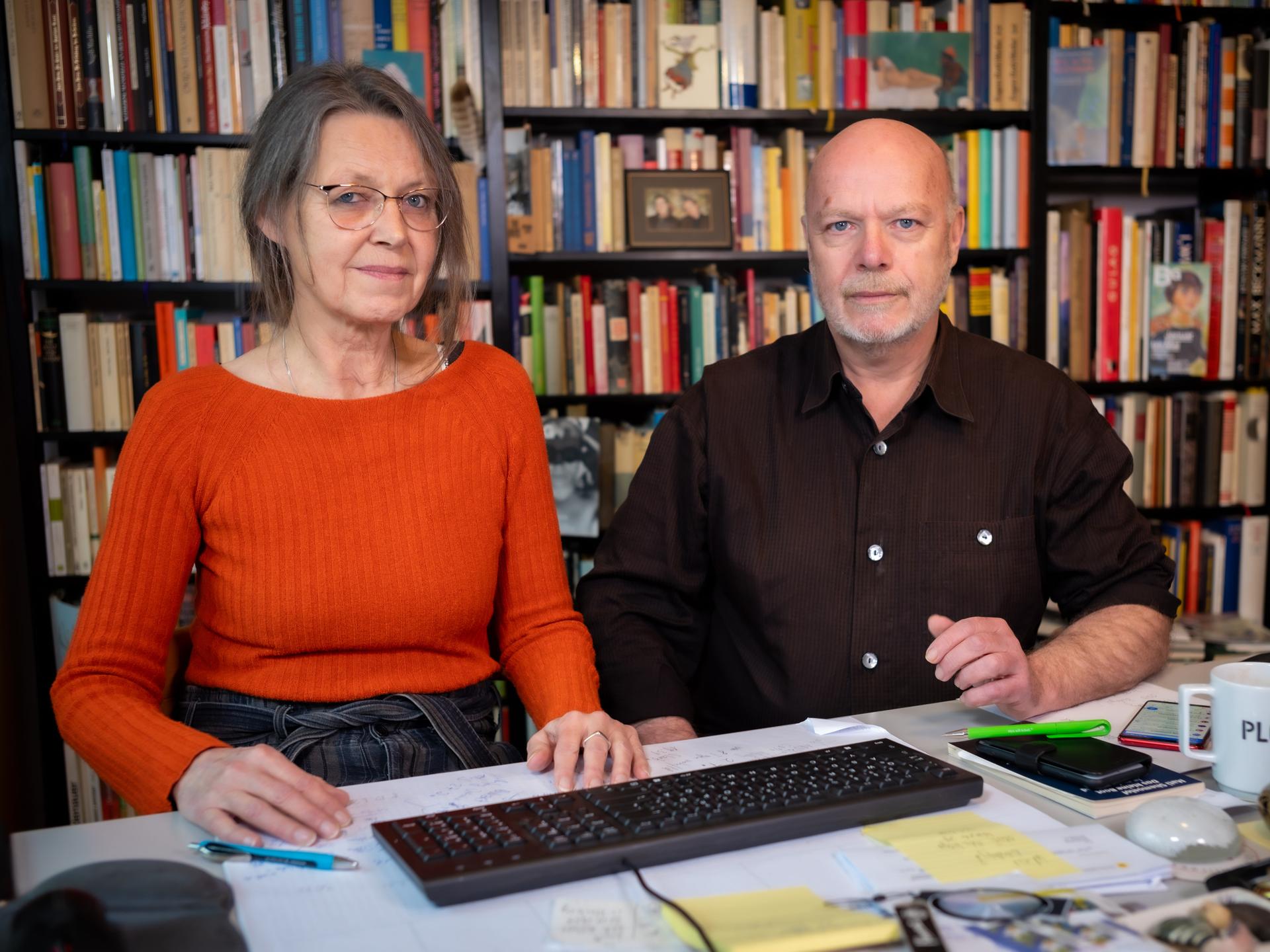 Eine Frau und ein Mann sitzen gemeinsam an einem Tisch. Es ist das Autorenduo Veronika Bock und Ulrich Biermann