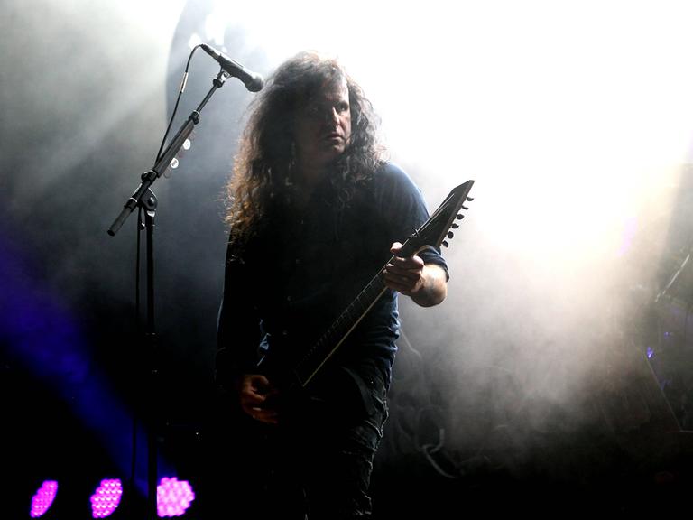 Der Sänger und Gitarrist der Metal-Band Kreator Mille Petrozza Kreator steht während eines Konzertes auf der Bühne.