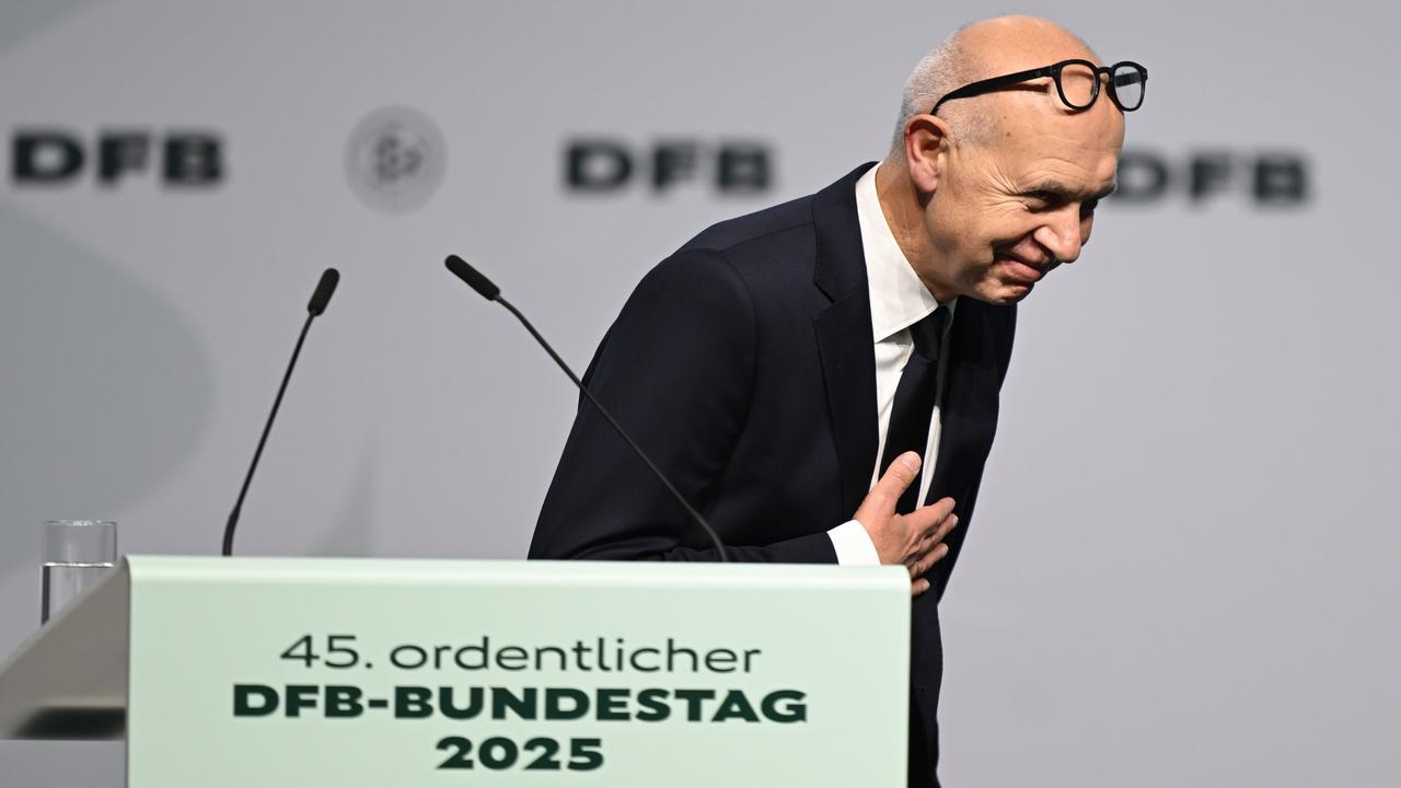 Neuendorf steht an einem Rednerpult und neigt sich zur Seite nach vorne. Er hält eine Hand ans Herz. 