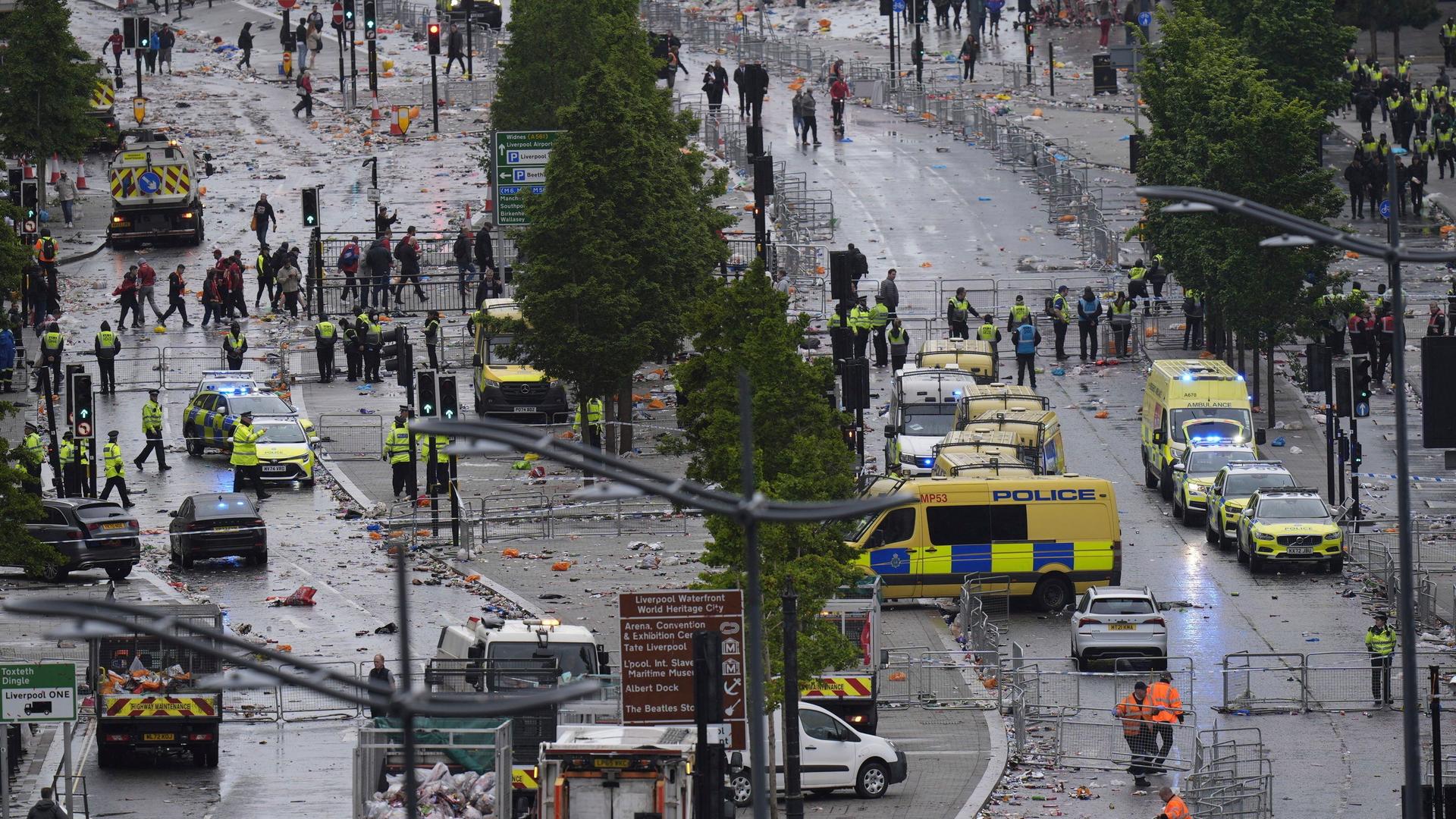 Viele Sicherheits- und Rettungskräfte auf einer stark vermüllten Straße Viele Sicherheits- und Rettungskräfte auf einer stark vermüllten Straße