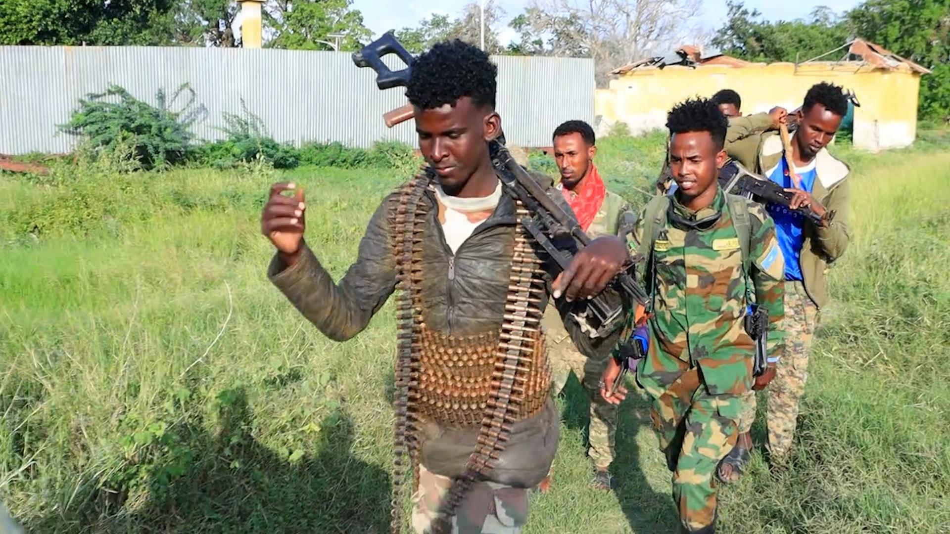 Eine Gruppe somalischer Soldaten geht über eine Wiese