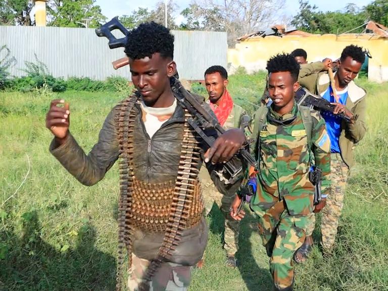 Eine Gruppe somalischer Soldaten geht über eine Wiese
