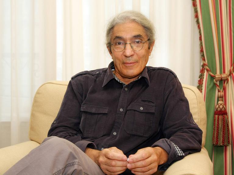 Der algerische Schriftsteller Boualem Sansal bei einem epd-Gespräch am 11.10.2011 in Frankfurt am Main. Er trägt ein dunkles Hemd, Brille und sitzt vor Vorhängen auf einem hellen Sessel.