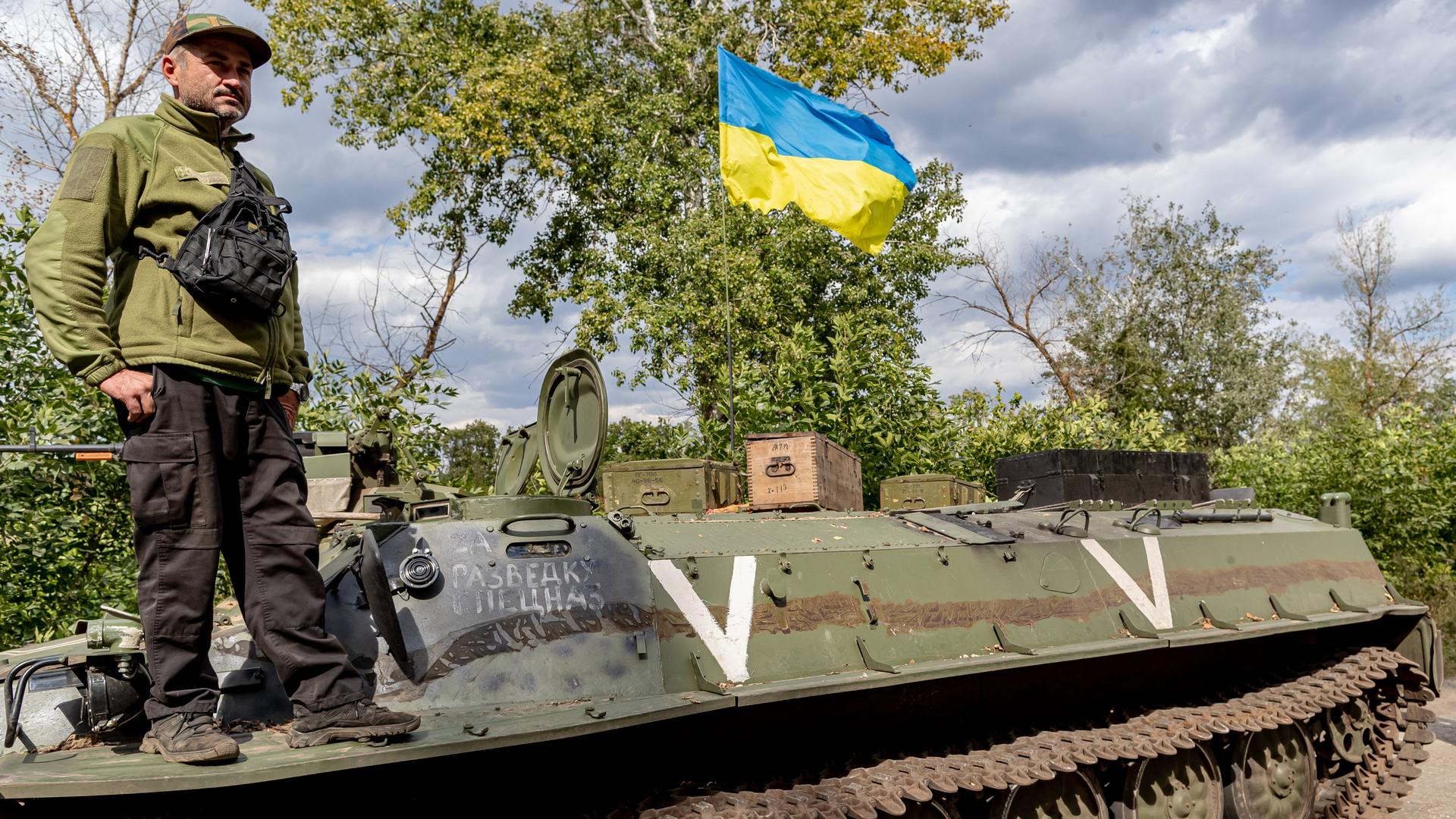 A Ukrainian soldier and a ukrainian national flag stands tall on a Russian abandoned tank which was captured by the Ukraine Armed Forces in eastern Ukraine on Thursday, Sept 8, 2022. (VX Photo/ Vudi Xhymshiti)