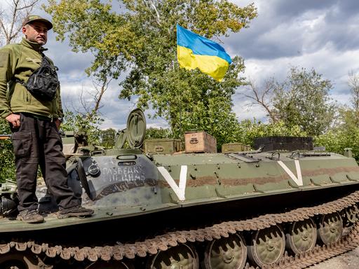 A Ukrainian soldier and a ukrainian national flag stands tall on a Russian abandoned tank which was captured by the Ukraine Armed Forces in eastern Ukraine on Thursday, Sept 8, 2022. (VX Photo/ Vudi Xhymshiti)