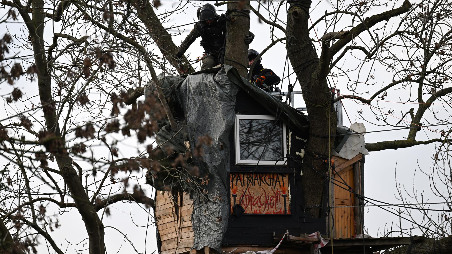 Polizisten stehen auf einem Baumhaus im sogenannten Fantasialand in Lützerath. 