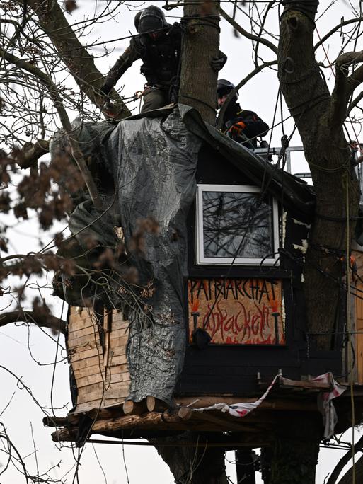 Polizisten stehen auf einem Baumhaus im sogenannten Fantasialand in Lützerath. 