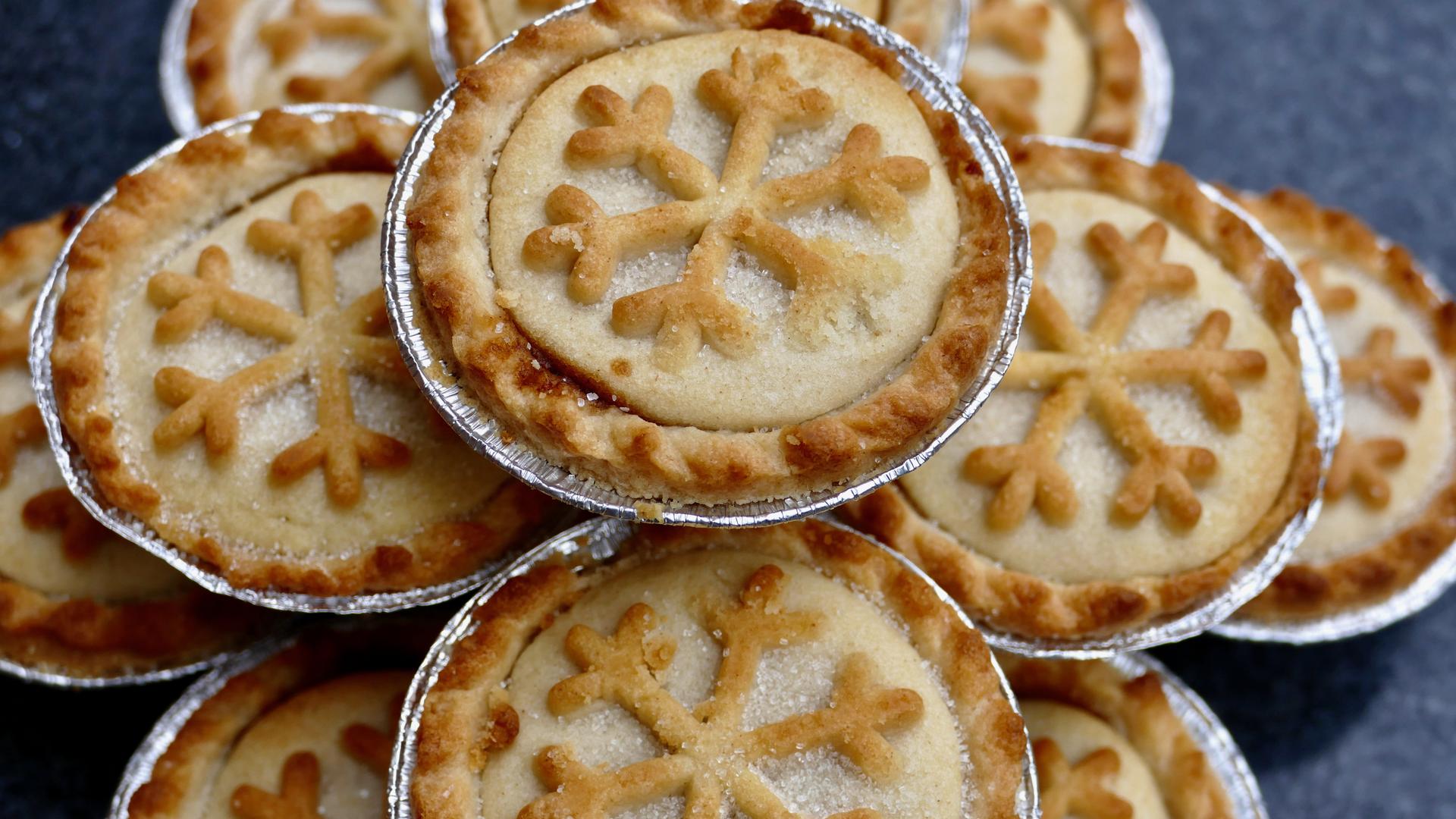 Weihnachtlich gestaltete Mince Pies: kleine runde Törtchen mit einem Schneeflockensymbol auf der Oberseite. Weihnachtlich gestaltete Mince Pies: kleine runde Törtchen mit einem Schneeflockensymbol auf der Oberseite.