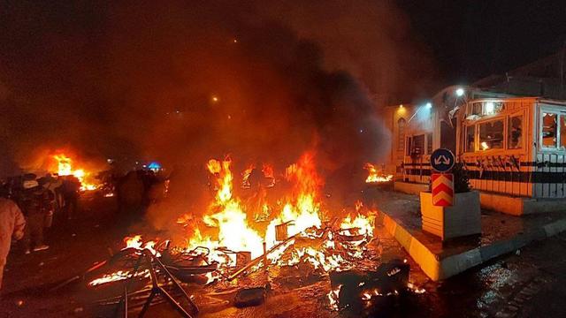 Ein Feuer auf Trümmern in einer dunklen Umgebung.