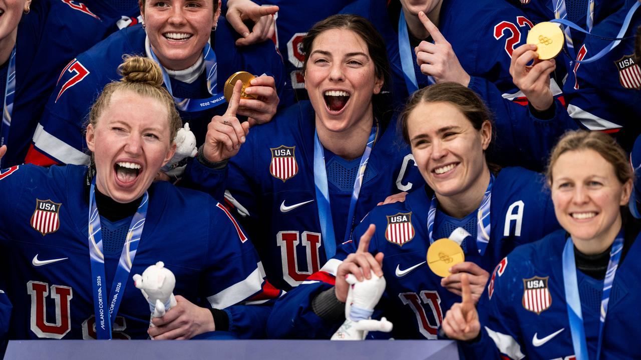 US-Eishockeyspielerinnen jubeln und halten ihre Olympia-Goldmedaillen in die Kamera.