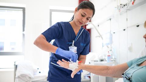 Die indische Pflegekraft Priyaraj Prabha legt einer Patientin eine Infusion. 