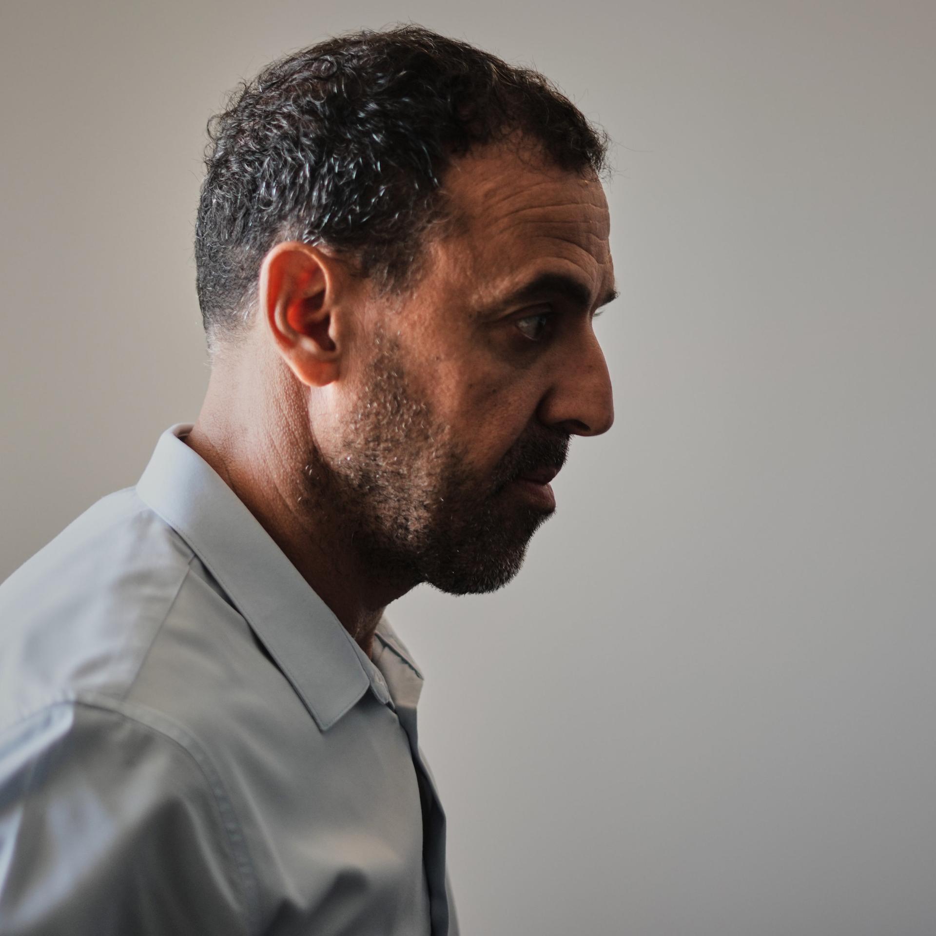 Ein Mann in Anzug, im Profil. Er blickt ernst: der Israeli Eli Sharabi, ehemals Geisel der Hamas.
