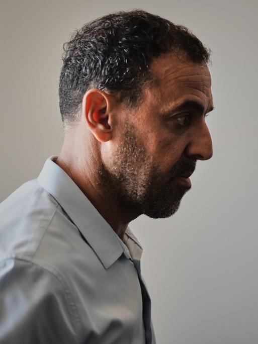 Ein Mann in Anzug, im Profil. Er blickt ernst: der Israeli Eli Sharabi, ehemals Geisel der Hamas.
