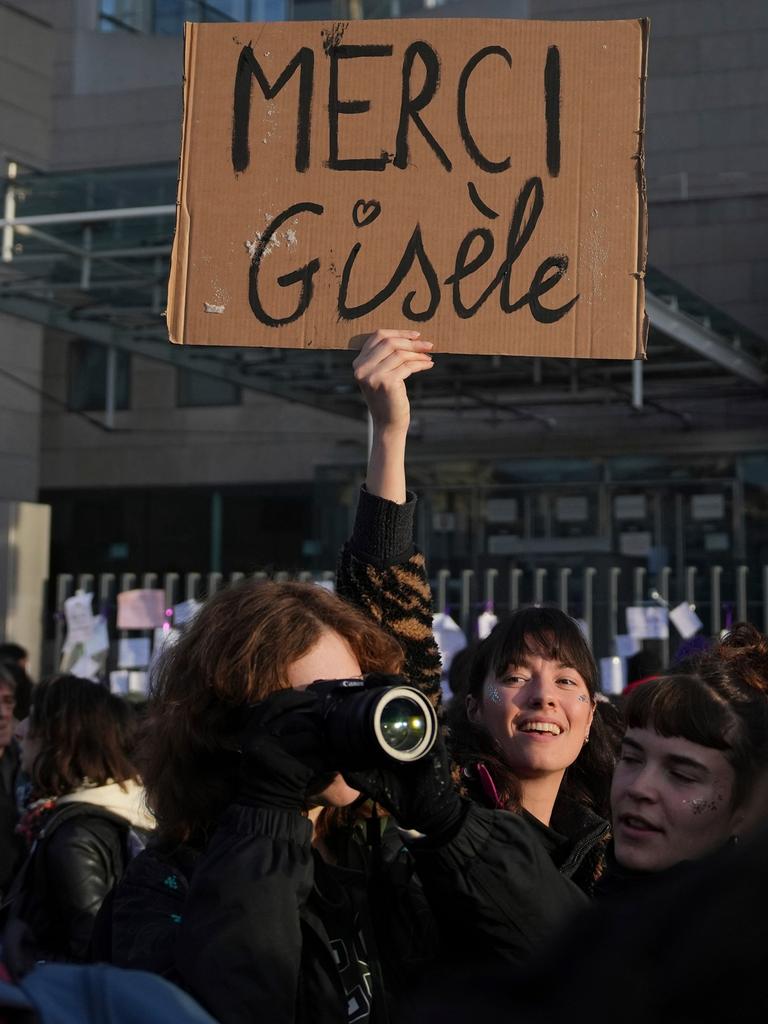 Eine Frau hält ein Plakat mit dem Schriftzug "Merci Gisèle" in die Höhe. 