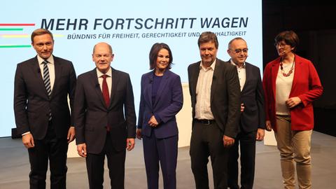 Von links nach rechts stehen Christian Lindner, Olaf Scholz, Annalena Baerbock, Robert Habeck, Norbert-Walter Borjans und Saskia Esken auf einer Bühne. Hinter ihnen die Aufschrift "Mehr Fortschritt wagen"