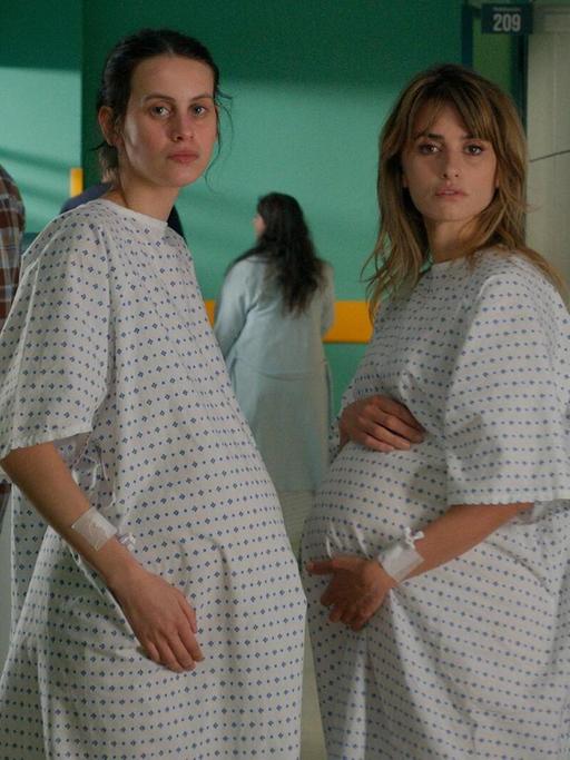 Die Schauspielerinnen Milena Smit und Penelope Cruz stehen in einer Szene aus dem Film "Parallele Mütter" hochschwanger in einem Krankenhausflur.