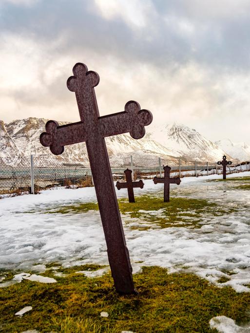 Gimsøy Kirche mit Friedhof, hinten schneebedeckte Berge, Winter, Gimsøya, Lofoten, Norwegen, Europa