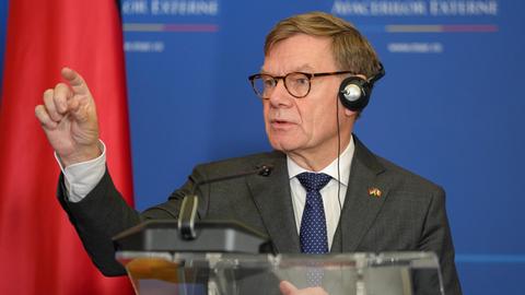 Bundesaußenminister Wadephul hat Kopfhörer auf und steht hinter einem Rednerpult.