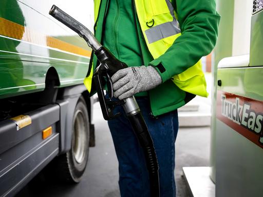 Ein Lkw-Fahrer tankt Diesel an einer Zapfsäule. Ein Lkw-Fahrer tankt Diesel an einer Zapfsäule.