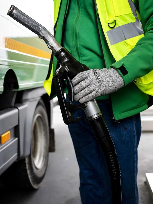 Ein Lkw-Fahrer tankt Diesel an einer Zapfsäule. Ein Lkw-Fahrer tankt Diesel an einer Zapfsäule.