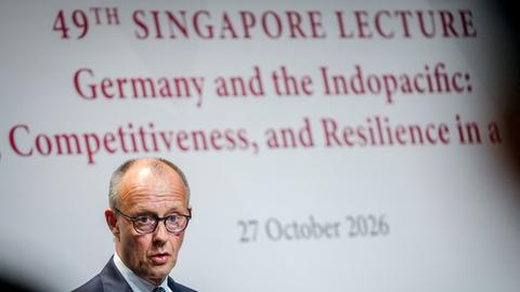 Merz spricht bei einer Vortragsreihe. Im Hintergrund ist der Schriftzug "Singapore Lecture" zu sehen.