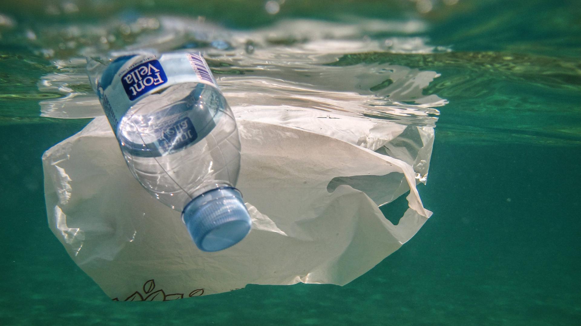 Unterwasseraufnahme zeigt Plastikflasche und Plastiktüte im Meer treibend. Unterwasseraufnahme zeigt Plastikflasche und Plastiktüte im Meer treibend.