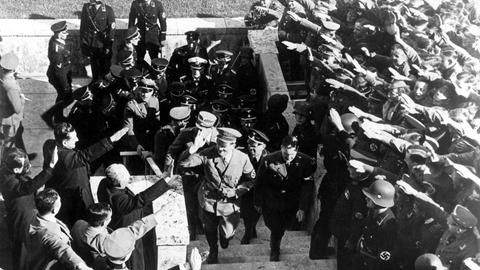 Adolf Hitler läuft die Stufen des Olympiastadions hoch und begrüßt Zuschauer