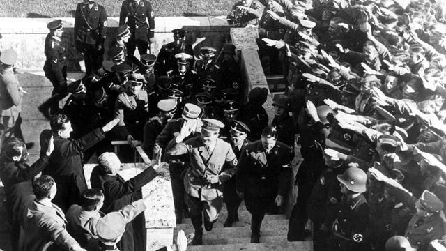 Adolf Hitler läuft die Stufen des Olympiastadions hoch und begrüßt Zuschauer Adolf Hitler läuft die Stufen des Olympiastadions hoch und begrüßt Zuschauer