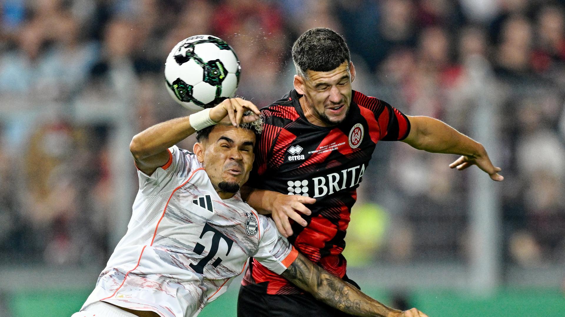 im DFB-Pokalspiel zwischen dem SV Wehen Wiesbaden und Bayern München liefern sich Luis Díaz (Bayern München) (l) und Jordy Gillekens (SV Wehen Wiesbaden) ein Kopfballduell. im DFB-Pokalspiel zwischen dem SV Wehen Wiesbaden und Bayern München liefern sich Luis Díaz (Bayern München) (l) und Jordy Gillekens (SV Wehen Wiesbaden) ein Kopfballduell.
